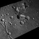 A view of craters and a group of mountains on Charon. The largest craters are about (30 miles) 50 km across.